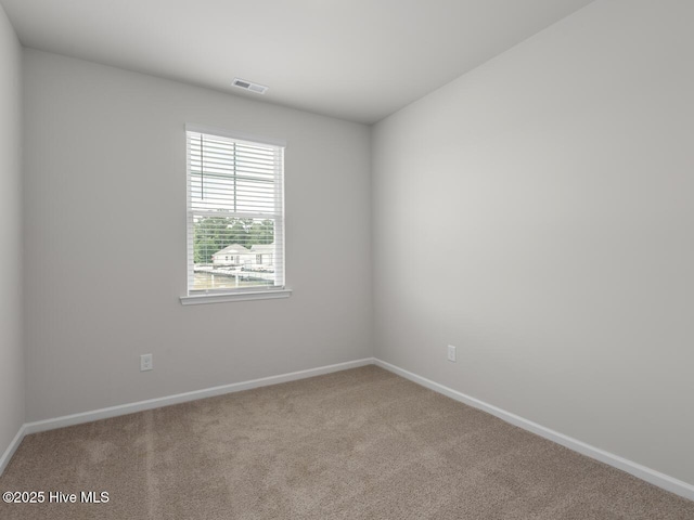 carpeted spare room featuring baseboards