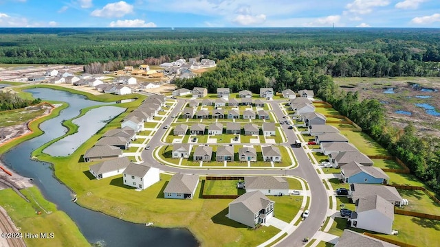 aerial view of residential area with a heavily wooded area and a large body of water