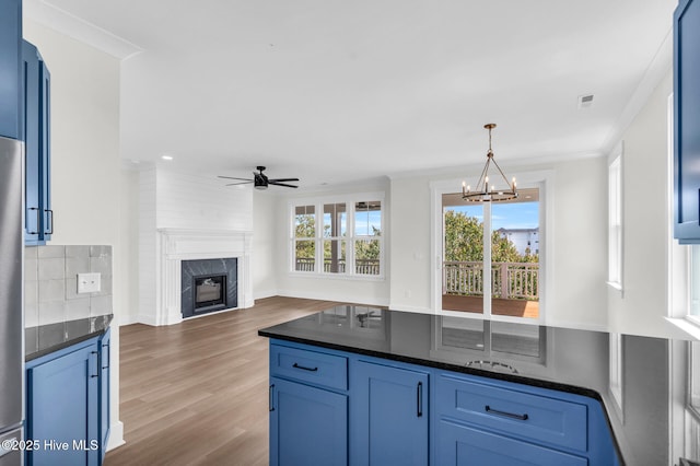 808 S 2nd St, Carolina Beach, NC 28428 - kitchen featuring a ceiling fan, a chandelier, a premium fireplace, wood finished floors, and hanging light fixtures