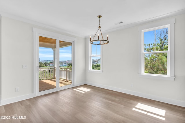 808 S 2nd St, Carolina Beach, NC 28428 - unfurnished room featuring a chandelier, healthy amount of natural light, wood finished floors, and ornamental molding