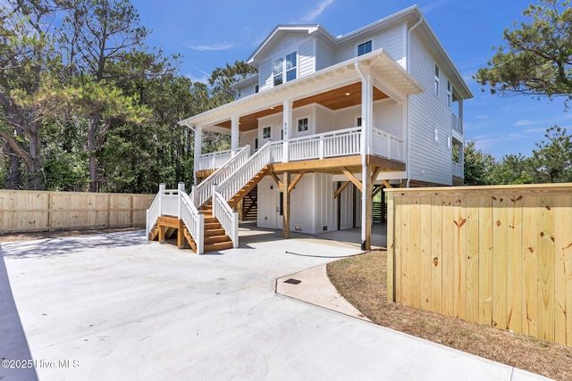 808 S 2nd St, Carolina Beach, NC 28428 - beach home with covered porch, stairway, a carport, fence, and concrete driveway