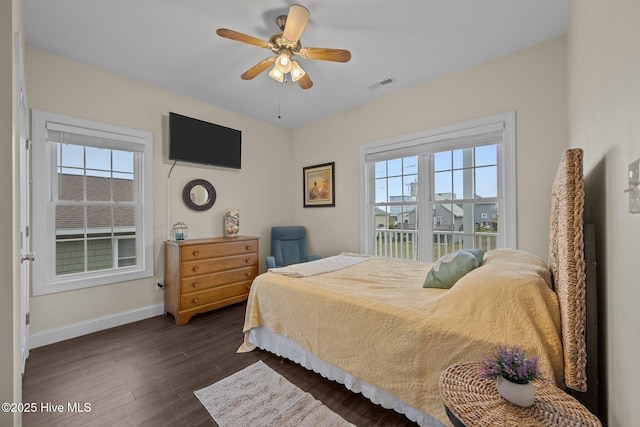 1711 S Anderson Blvd, Holly Ridge, NC 28445 - bedroom featuring multiple windows, baseboards, dark wood-style floors, and a ceiling fan