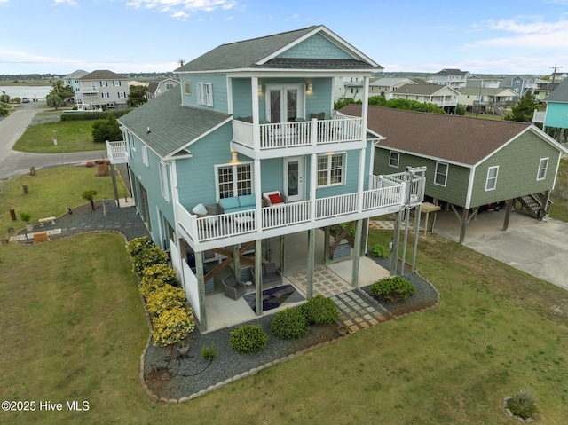 1711 S Anderson Blvd, Holly Ridge, NC 28445 - rear view of house featuring a balcony, roof with shingles, a patio area, and a yard