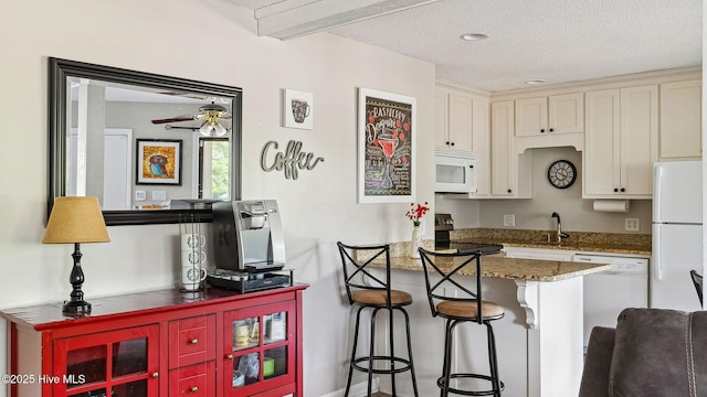 227 Foxkroft Dr Unit 9, Foxfire Village, NC 27281 - kitchen featuring white appliances, a sink, a peninsula, white cabinetry, and a breakfast bar