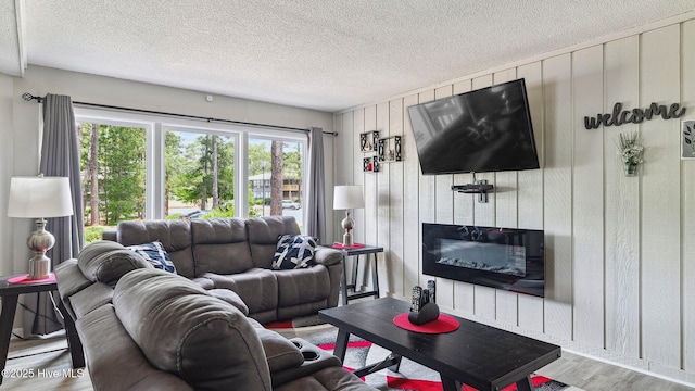 227 Foxkroft Dr Unit 9, Foxfire Village, NC 27281 - living room featuring wood finished floors, wooden walls, a fireplace, and a textured ceiling