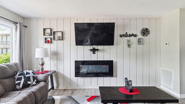 227 Foxkroft Dr Unit 9, Foxfire Village, NC 27281 - living room featuring wood finished floors, plenty of natural light, a textured ceiling, wooden walls, and baseboards