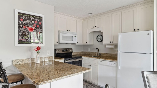 227 Foxkroft Dr Unit 9, Foxfire Village, NC 27281 - kitchen with white appliances, a sink, a peninsula, white cabinetry, and a textured ceiling