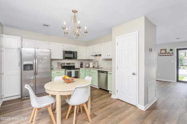 4 Port W Ct Unit C, Swansboro, NC 28584 - kitchen with stainless steel appliances, a chandelier, light countertops, and light wood-style floors