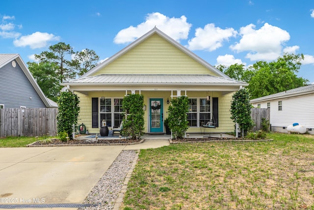131 NE 33rd St, Oak Island, NC 28465 - view of front of house featuring covered porch and metal roof