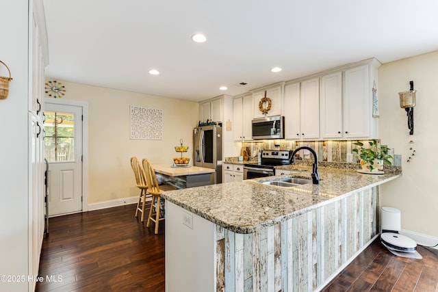 131 NE 33rd St, Oak Island, NC 28465 - kitchen featuring appliances with stainless steel finishes, baseboards, dark wood-style flooring, a sink, and recessed lighting