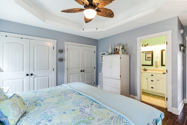 131 NE 33rd St, Oak Island, NC 28465 - bedroom with a tray ceiling, two closets, wood finished floors, baseboards, and ensuite bath
