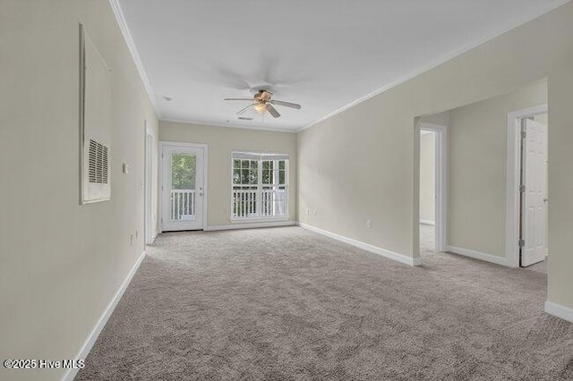 carpeted spare room featuring crown molding, a ceiling fan, and baseboards