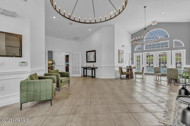 common area featuring a decorative wall, high vaulted ceiling, a wainscoted wall, and recessed lighting