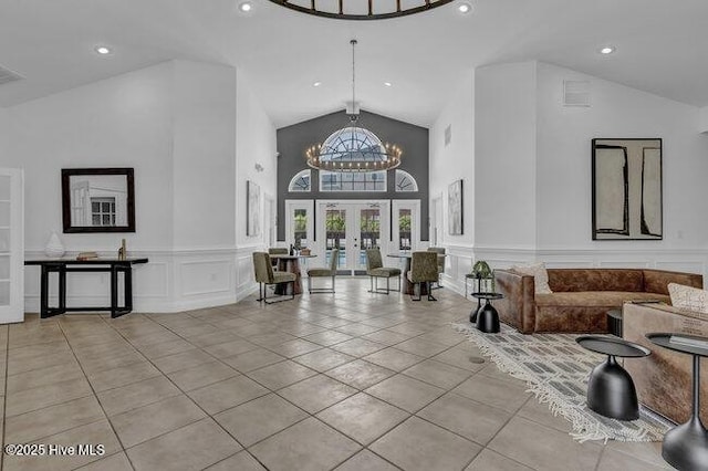 building lobby featuring a decorative wall, high vaulted ceiling, recessed lighting, and a wainscoted wall
