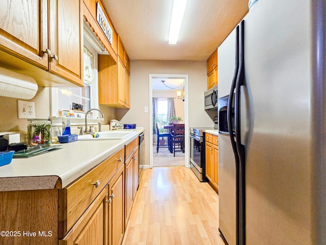 889 NC Highway 37 N, Gates, NC 27937 - kitchen featuring appliances with stainless steel finishes, a sink, light wood-style flooring, light countertops, and brown cabinetry
