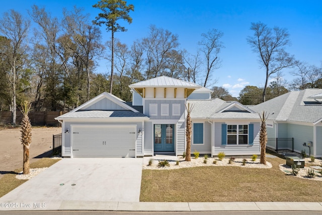 view of front facade featuring french doors, a garage, driveway, and board and batten siding