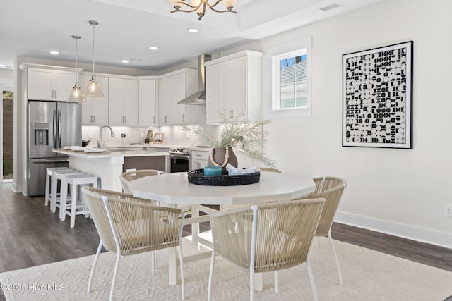 dining area featuring dark wood finished floors, recessed lighting, a chandelier, and baseboards
