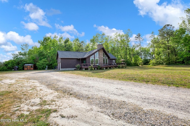 181 Kirkpatrick Ln, Red Springs, NC 28377 - mid-century inspired home featuring dirt driveway, a chimney, a deck, a storage unit, and a front yard