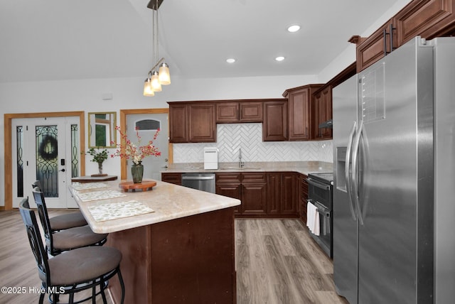 181 Kirkpatrick Ln, Red Springs, NC 28377 - kitchen with appliances with stainless steel finishes, light countertops, light wood-type flooring, tasteful backsplash, and a sink
