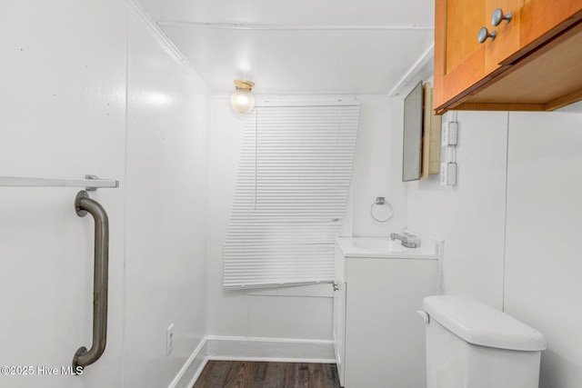 bathroom featuring wood finished floors, vanity, baseboards, and toilet