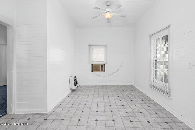 spare room with light flooring, ceiling fan, heating unit, and cooling unit