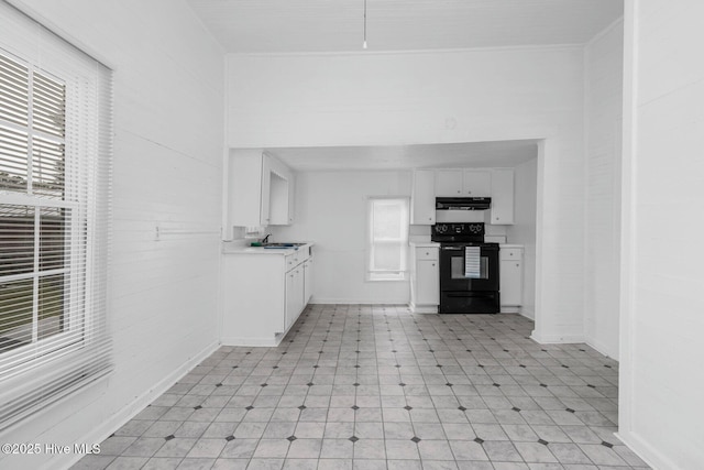 kitchen with electric range, healthy amount of natural light, range hood, and white cabinets