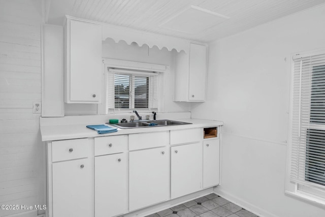 kitchen with a sink, light countertops, and white cabinets