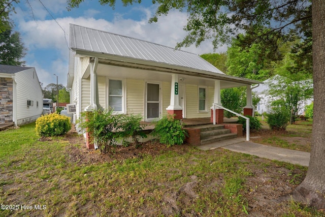 bungalow-style house featuring covered porch and metal roof