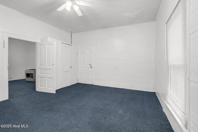 unfurnished bedroom featuring dark carpet and a ceiling fan
