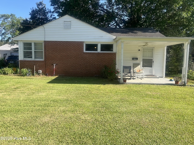 rear view of house with a lawn, brick siding, and covered porch