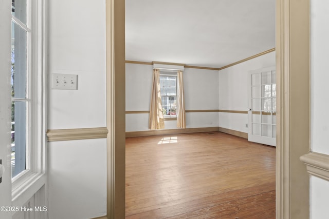 306 S Oakum St, Edenton, NC 27932 - empty room featuring wood finished floors, ornamental molding, healthy amount of natural light, and baseboards
