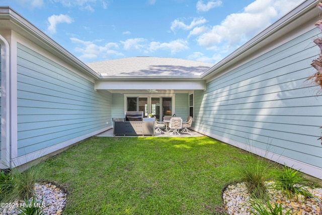 view of grassy yard featuring a patio, a ceiling fan, and an outdoor kitchen