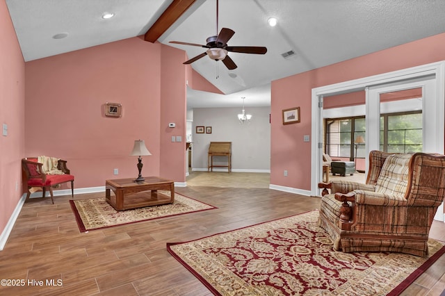 living room with wood finished floors, ceiling fan, baseboards, and a chandelier