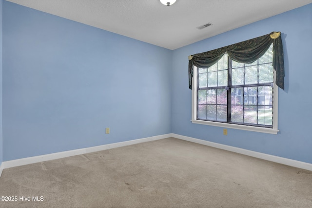 spare room featuring carpet flooring and baseboards