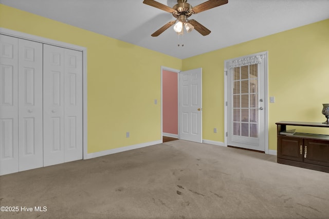 unfurnished bedroom with baseboards, carpet, ceiling fan, and a closet