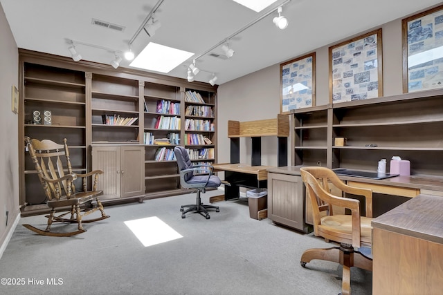 home office featuring built in study area, rail lighting, and carpet