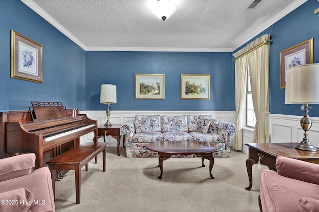 living area with a textured ceiling, carpet, crown molding, and a wainscoted wall