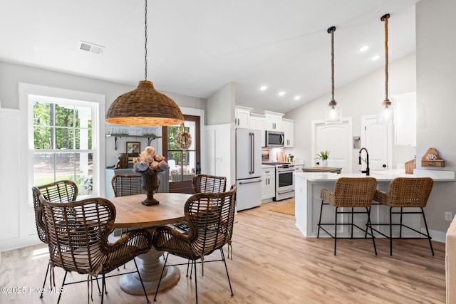 dining area with vaulted ceiling, light wood-type flooring, and recessed lighting