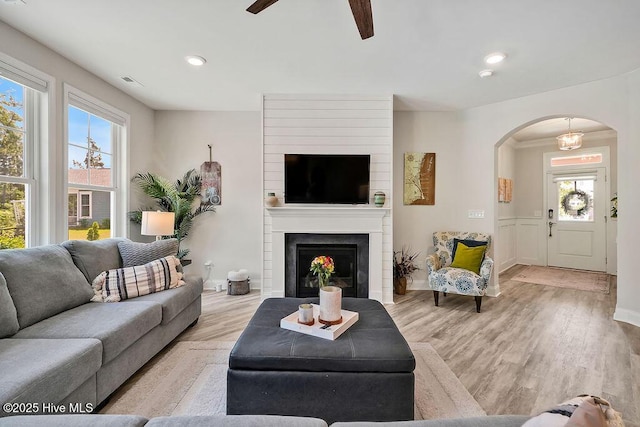 living area featuring arched walkways, a ceiling fan, wood finished floors, recessed lighting, and baseboards