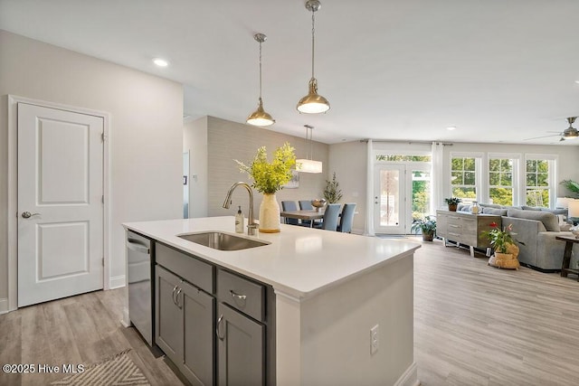 kitchen with a sink, gray cabinetry, dishwasher, open floor plan, and a ceiling fan