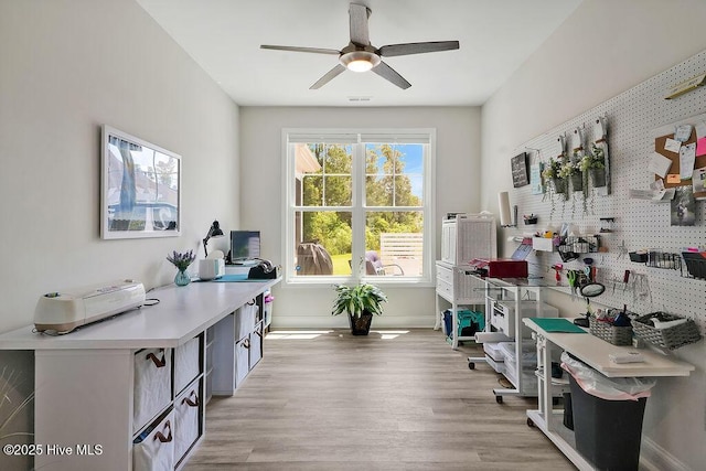 office featuring a ceiling fan, light wood-style floors, and baseboards
