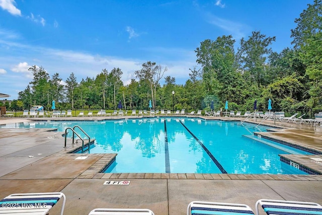 community pool with a patio and fence