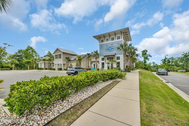 view of property with uncovered parking and a residential view