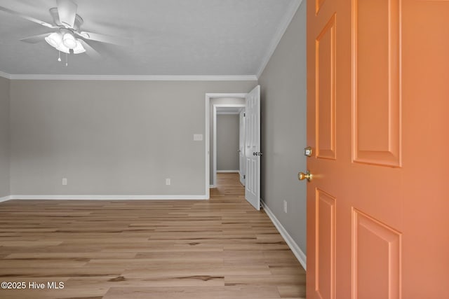 unfurnished room featuring a ceiling fan, crown molding, light wood-style floors, and baseboards