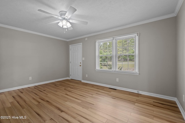 spare room featuring light wood finished floors, baseboards, ornamental molding, ceiling fan, and a textured ceiling