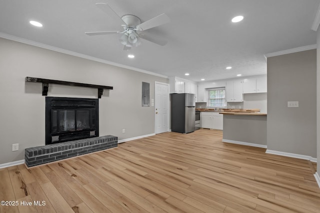 unfurnished living room with crown molding, baseboards, light wood-style flooring, recessed lighting, and ceiling fan