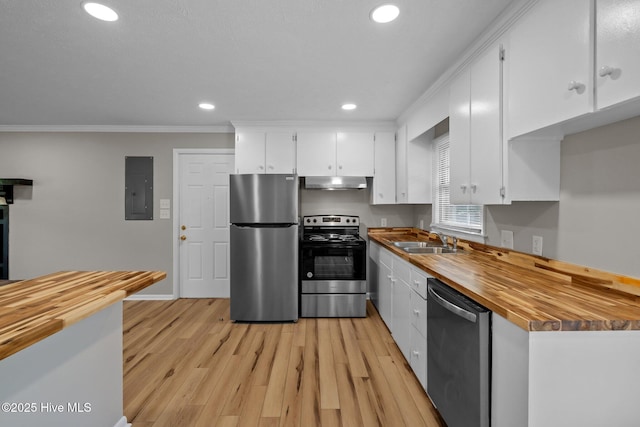 kitchen with stainless steel appliances, butcher block counters, a sink, electric panel, and under cabinet range hood