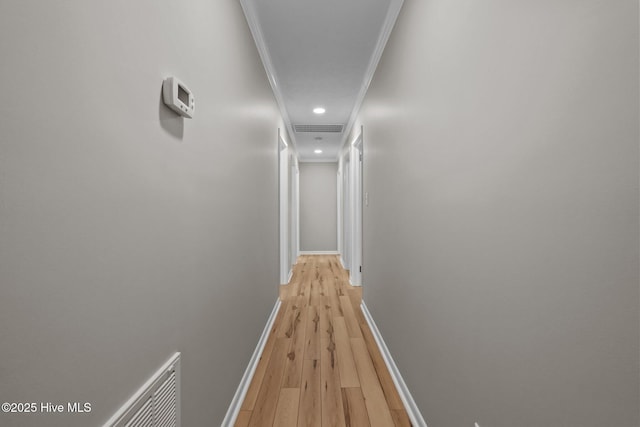 hall featuring crown molding, baseboards, light wood-style floors, and recessed lighting