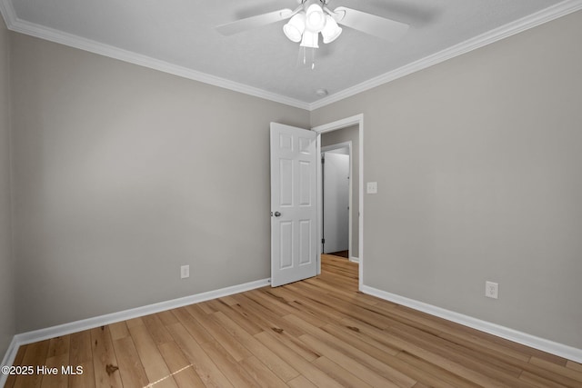 unfurnished room with light wood-style floors, ornamental molding, baseboards, and a ceiling fan
