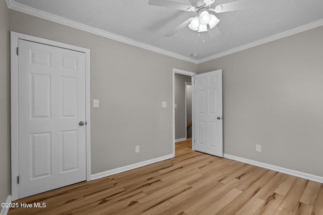 unfurnished bedroom with wood finished floors, baseboards, crown molding, and a ceiling fan